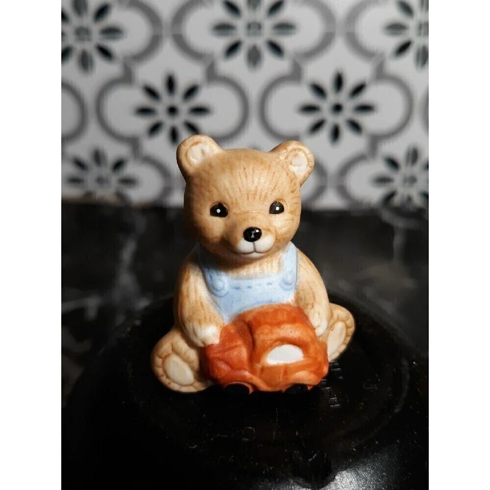 Tiny bear playing with car figurine